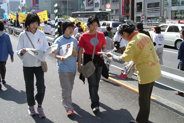 法轮功学员向群众散发真相材料(大纪元摄影) 法轮功学员向群众散发真相材料(大纪元摄影)