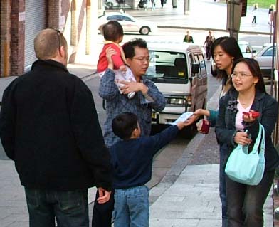 小义工向路人传递九评退党的资料(大纪元) 小义工向路人传递九评退党的资料(大纪元)