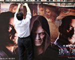 北京在《达芬奇密码》开演后突然决定禁演。上海一家影院的工作人员无奈取下该电影的大幅广告。(MARK RALSTON/AFP/Getty Images)
