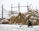 茅草屋旁正在除雪的妇女，该图摄于中国西藏八宿县(Photo by China Photos/Getty Images)