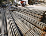 2006年9月13日。一北京三轮车夫经过一堆放在建筑工地旁的钢条。北京政府正在经受生产过度的危机﹐采取宏观调控来减缓过热的经济。(PETER PARKS/AFP/Getty Images)