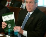 2007年2月5日，美国华盛顿。布什总统在白宫手拿着一本他的2008年财政预算回答记者提问。（Ron Sachs-Pool/Getty Images）