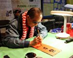 司徒华指中共一直采取“打进去”和“拉出来”的方法分裂其它团体。图为他在维多利亚公园的年宵市场为市民写挥春。(大纪元记者吴琏宥摄)