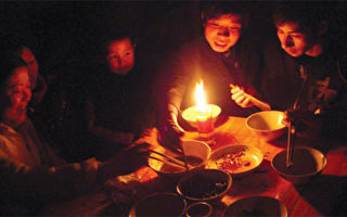 二零零八年二月四日，中國新年除夕之夜，湖南郴州一戶人家點蠟燭在昏暗的光線下過年。當時，該地由於暴風雪襲擊已經停電兩個星期。（法新社）