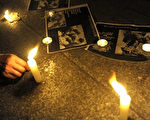 一名成都男子点燃蜡烛，悼念5.12四川特大地震中遇难的孩子（08年6月12日法新社）