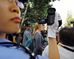 中國警察正在拍攝接受記者採訪的外國示威者（22日/GOH CHAI HIN/AFP/Getty Images)