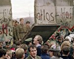 20年前，西德民眾聚集在柏林墻前，看到東德的士兵砸開了一個大缺口。（法新社）
