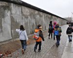 1989年11月9日，分隔东西柏林和东西德的柏林墙倒塌，促进了东西德的统一，随后全世界的共产阵营也陆续垮台。图为2009年柏林墙倒塌20周年时，人们走过部分保留下来的柏林墙。（李家祥FEFERBERG／法新社）