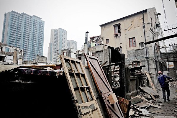 据BBC报道，2009年，中国房地产市场进入“癫狂状态”，房价暴涨。老百姓的收入和房价之间的差距越来越大。图为3月2日上海民房被摧毁来盖高楼，美国灾难性的房地产泡沫，仍在蔓延。（PHILIPPE LOPEZ/AFP/Getty Images）