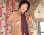 2010年图片：被迫害致疯的柳志梅，当有人试图接近，她就攥著双手躲向自家墙角。（明慧网）