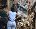 飓风“马修”（Matthew）今天横扫中美洲，风雨造成加勒比海内湾水灾和土石流，至少14人因此丧命。图为9月25日在委内瑞拉加拉加斯，居民无奈地注视着暴雨造成的灾难。（MIGUEL GUTIERREZ/AFP/Getty Images)
