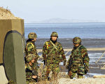 11月26日，韩国海军陆战队的士兵在延坪岛站岗。由于隔海相望的朝鲜当日再次发出隆隆炮声，并威胁发动更多袭击，恐惧弥漫着处于争议海域中的韩国边境群岛。（DONG-A ILBO/AFP/Getty Images）
