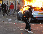 英國一連4天的暴動震撼世人，街頭幫派是推助暴動的主因。圖為2011年8月8日在英國倫敦克拉倫斯路暴徒向防暴警察投擲石頭。（圖片來源：Dan Istitene／Getty Images）
