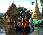 曼谷市區到處淹水，連寺廟僧侶都得用小船代步。（AFP）