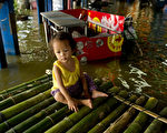 2011年11月7日，洪水現在已經流抵泰國曼谷市中心外圍。圖為一個小女孩坐在竹筏上。（圖片來源：NICOLAS ASFOURI/AFP/Getty Images）