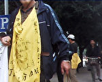 11月29日上午約十點，福建省福州市、福清市等地100多位訪民從福建省最高人民法院步行至省人民代表大會堂門前抗議當局不作為。圖為身穿黃色狀衣的訪民。（志願者提供）