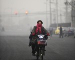 美国驻中国大使馆5日发布的北京空气品质达到危险的程度，而北京环保局同日公布的数据则称北京空气质量属于轻度污染。民众出门都戴着口罩。（STF: LIU JIN / AFP ImageForum）