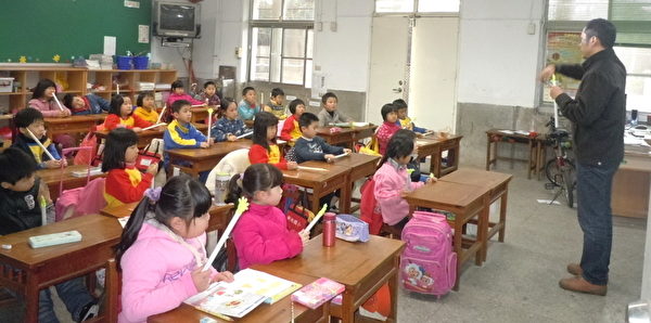 透过教导学生手摇旗或举手过马路,提升学生穿越马路的安全性。(摄影:徐乃义/大纪元) 透过教导学生手摇旗或举手过马路,提升学生穿越马路的安全性。(摄影:徐乃义/大纪元)