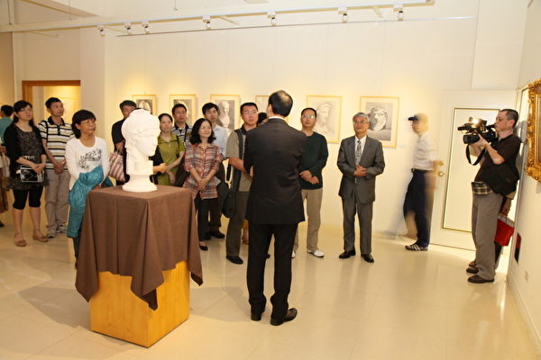 李园正在为观众导览画作(摄影:廖平风/大纪元) 李园正在为观众导览画作(摄影:廖平风/大纪元)