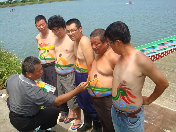 画家林新来在5壮汉的肚子上彩绘龙舟竞赛图(摄影:徐乃义/大纪元) 画家林新来在5壮汉的肚子上彩绘龙舟竞赛图(摄影:徐乃义/大纪元)