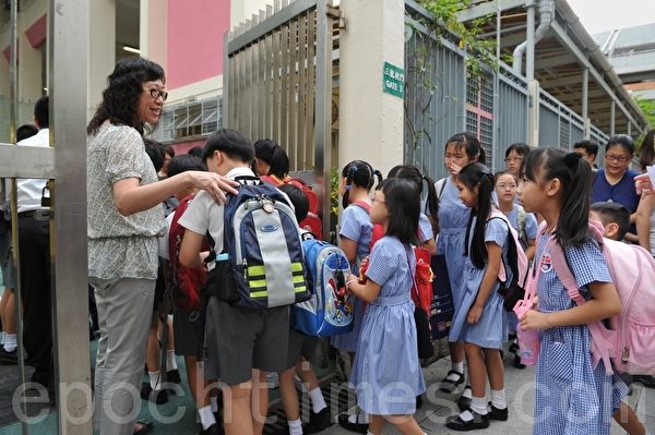多間小學表明會在新學期開展國教科,其中沙田浸信會呂明才小學開學日,部分家長穿上黑衣表達不滿,子女書包及手上也縛上黑絲帶,表達憤怒,並將黑衣師生相片上載互聯網。(攝影:宋祥龍/大紀元) 多間小學表明會在新學期開展國教科,其中沙田浸信會呂明才小學開學日,部分家長穿上黑衣表達不滿,子女書包及手上也縛上黑絲帶,表達憤怒,並將黑衣師生相片上載互聯網。(攝影:宋祥龍/大紀元)