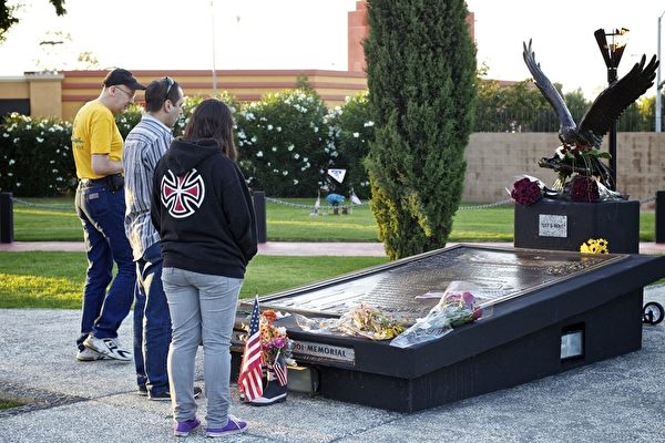 图：圣荷西民众在纪念碑前观看恐怖攻击事件的罹难者姓名，或许在寻找曾经的亲友。（摄影：李欧／大纪元）
