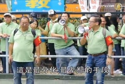 今年11月25日,聽命於梁振英的青關會頭目林國安(綠衣前左一)和楊江(綠衣前右一)身帶紅袖章,糾集徒眾,在路邊干擾法輪功學員舉辦的退黨遊行。楊江用高聲喇叭高叫汙衊法輪功的口號。(新唐人電視台擷圖) 今年11月25日,聽命於梁振英的青關會頭目林國安(綠衣前左一)和楊江(綠衣前右一)身帶紅袖章,糾集徒眾,在路邊干擾法輪功學員舉辦的退黨遊行。楊江用高聲喇叭高叫汙衊法輪功的口號。(新唐人電視台擷圖)