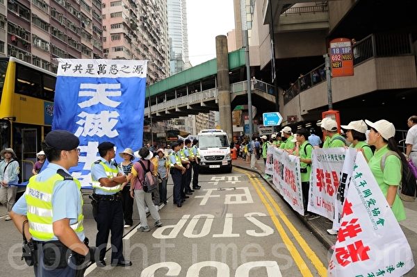 在江派大管家、前中國國家副主席曾慶紅授意下,梁振英夥同香港江湖富商楊受成在香港再現「文革」場面,大批青關會成員聚眾鬧事,吹奏口哨和喇叭,發出極大噪音。11月25日,青關會派出身穿綠衣的數百人聚眾鬧事,干擾法輪功學員舉辦的退黨遊行。(大紀元圖片) 在江派大管家、前中國國家副主席曾慶紅授意下,梁振英夥同香港江湖富商楊受成在香港再現「文革」場面,大批青關會成員聚眾鬧事,吹奏口哨和喇叭,發出極大噪音。11月25日,青關會派出身穿綠衣的數百人聚眾鬧事,干擾法輪功學員舉辦的退黨遊行。(大紀元圖片)
