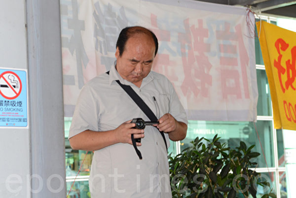 在曾慶紅、梁振英授意下,青關會雇傭配備專業攝影器材來滋擾香港法輪功真相點的幫兇。(大紀元圖片) 在曾慶紅、梁振英授意下,青關會雇傭配備專業攝影器材來滋擾香港法輪功真相點的幫兇。(大紀元圖片)