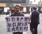 廣州「舉牌哥」劉輝在廣州繁華地段再次舉牌,實名舉出的標語是:「打倒共產黨獨裁!」和「共產黨是共匪!」。(知情者提供)