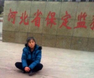 悲愤的郑祥星妻子孙素云坐在保定监狱外冰冷的水泥地上,向社会呼救。(图片来源:明慧网) 悲愤的郑祥星妻子孙素云坐在保定监狱外冰冷的水泥地上,向社会呼救。(图片来源:明慧网)