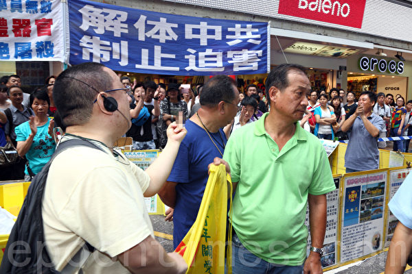 一名市民進入警戒線內,對青關會惡徒示不文手勢表達不滿。旁邊的市民歡呼拍掌。(攝影:潘在殊/大紀元) 一名市民進入警戒線內,對青關會惡徒示不文手勢表達不滿。旁邊的市民歡呼拍掌。(攝影:潘在殊/大紀元)