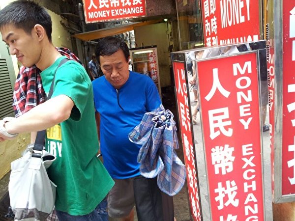 报纸上架才一星期已经遭到滋扰,被人有组织地在旺角多个报摊偷拿。有香港市民举报,发现有青关会成员派人在报摊附近观察,看准时机,以快速手法拿走,从十几份到几十份不等。图中恶汉(蓝衫者)手拿的黑色袋子内也载了不少大纪元报纸,当他发现有被大纪元发行人员盯住后,立即逃走。(摄影:博女士) 报纸上架才一星期已经遭到滋扰,被人有组织地在旺角多个报摊偷拿。有香港市民举报,发现有青关会成员派人在报摊附近观察,看准时机,以快速手法拿走,从十几份到几十份不等。图中恶汉(蓝衫者)手拿的黑色袋子内也载了不少大纪元报纸,当他发现有被大纪元发行人员盯住后,立即逃走。(摄影:博女士)