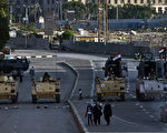 8月18日，埃及军方的武装运兵车停靠在埃及首都开罗的解放广场中的埃及博物馆前。一周以来，埃及前总统穆尔西的支持者和军方的冲突导致750人死亡。(KHALED DESOUKI/AFP/Getty Images)