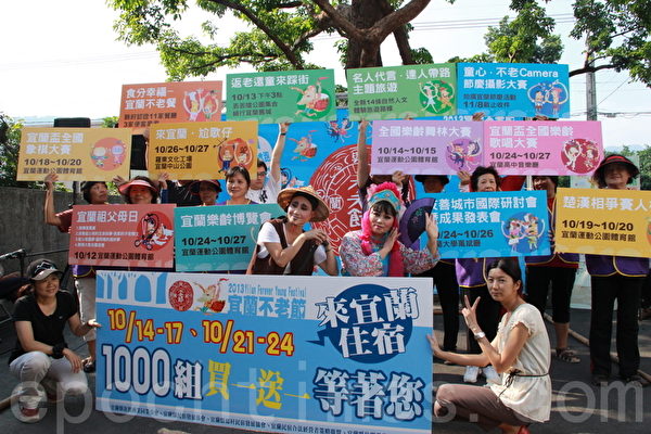 2013宜兰不老节的12项活动看板,前排中为结头份歌仔戏班的班员。(谢月琴/大纪元) 2013宜兰不老节的12项活动看板,前排中为结头份歌仔戏班的班员。(谢月琴/大纪元)