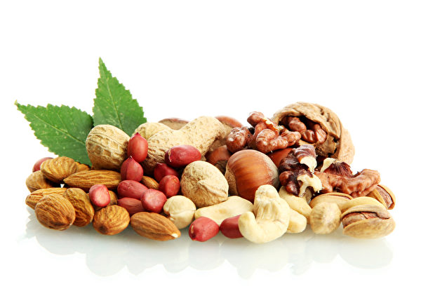 assortment of tasty nuts with leaves, isolated on white assortment of tasty nuts with leaves, isolated on white