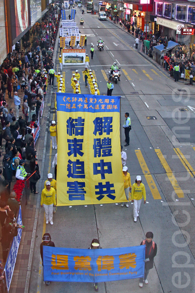 香港法轮功学员12月1日举行庆祝九评九周年及声援一亿五千万中国民众退出中共组织集会，游行队伍由九龙长沙湾游乐场出发，途经九龙区闹市，声势浩大的游行场面震撼许多大陆游客。（潘在殊/大纪元）