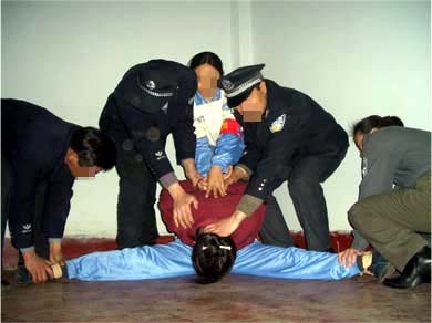酷刑演示:強行將受害者的雙腿一字劈開 (圖片來源:明慧網) 酷刑演示:強行將受害者的雙腿一字劈開 (圖片來源:明慧網)