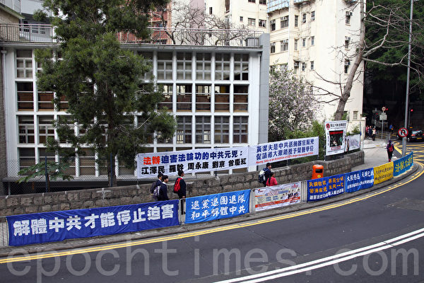 法輪功學員在港大正門外掛起揭露黃潔夫的橫額,引來不少學生觀看。(潘在殊/大紀元) 法輪功學員在港大正門外掛起揭露黃潔夫的橫額,引來不少學生觀看。(潘在殊/大紀元)