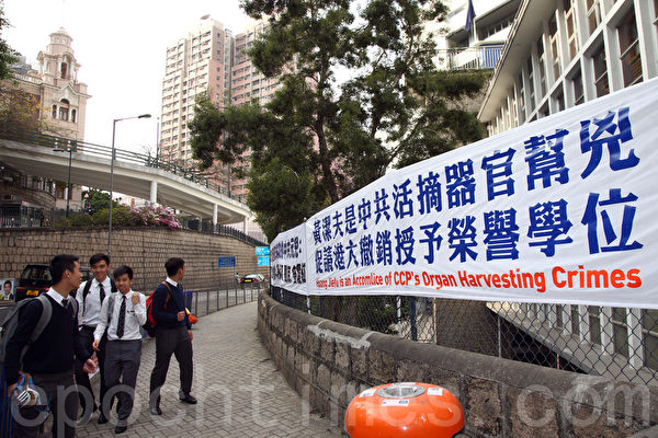 法輪功學員在港大正門外掛起揭露黃潔夫的橫額,引來不少學生觀看。(潘在殊/大紀元) 法輪功學員在港大正門外掛起揭露黃潔夫的橫額,引來不少學生觀看。(潘在殊/大紀元)