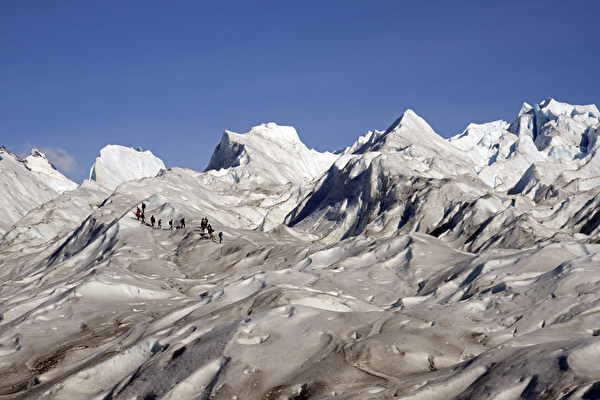游客跋涉阿根廷冰川国家公园内的莫雷诺冰川。（MARIO GOLDMAN／AFP）