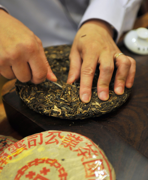 用工具从已制好的茶饼上把茶剥下来,准备泡茶。(图/Getty Images) 用工具从已制好的茶饼上把茶剥下来,准备泡茶。(图/Getty Images)