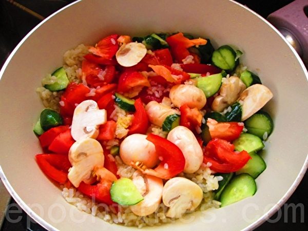 作程1：绿咖喱彩蔬饭--锅中热好油，放入了米饭、蔬菜材料。（摄影：家和／大纪元）