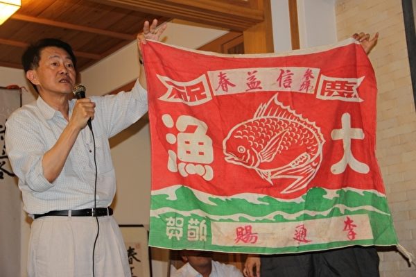 庄伯和拿着渔船要出港的旗帜。(谢月琴/大纪元) 庄伯和拿着渔船要出港的旗帜。(谢月琴/大纪元)