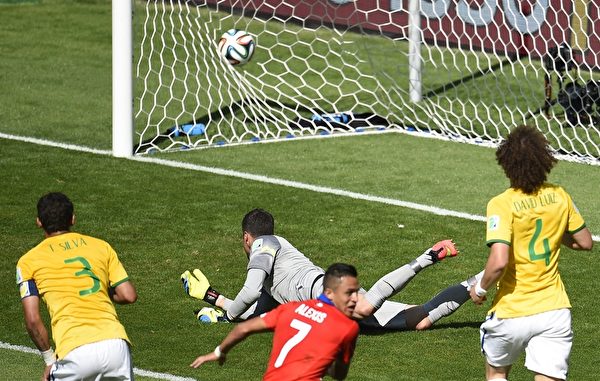 6月28日巴西同智利的世界杯16强首场对阵的第32分钟，智利头号球星桑切斯抢到巴西后卫传入禁区的球后冷静推射远角得手，双方战成1-1。(ODD ANDERSEN/AFP/Getty Images)