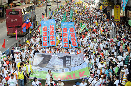 2009年七一大游行的主题为“施政失误、贫富悬殊、还政于民、改善民生”。图为2009年7月1日,香港,参加游行的队伍。(MIKE CLARKE/AFP)