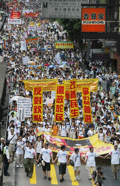 2005年七一大游行的主题为“反对官商勾结,争取全面普选”。图为2005年7月1日,香港,参加游行。(Richard A. BROOKS/AFP)