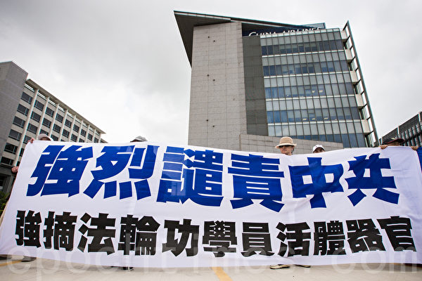 法轮功学员6月25日在诺富特机场饭店外,拉起横幅“强烈谴责中共,强摘法轮功学员活体器官”。(陈柏州/大纪元) 法轮功学员6月25日在诺富特机场饭店外,拉起横幅“强烈谴责中共,强摘法轮功学员活体器官”。(陈柏州/大纪元)