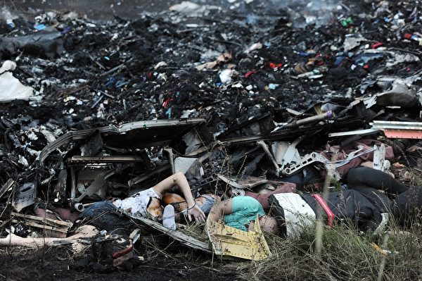 马航MH-17班机7月17日疑遭飞弹击落,机上298名乘客及机组人员全数罹难。图为失事现场一片狼藉,飞机残骸及罹难者遗体、遗物四处散落。(DOMINIQUE FAGET/AFP/Getty Images) 马航MH-17班机7月17日疑遭飞弹击落,机上298名乘客及机组人员全数罹难。图为失事现场一片狼藉,飞机残骸及罹难者遗体、遗物四处散落。(DOMINIQUE FAGET/AFP/Getty Images)
