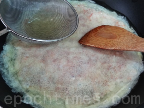下油鍋炸至兩面金黃，用漏勺和木飯匙壓蝦餅皮，防止起泡、分離。(攝影：彩霞/大紀元)